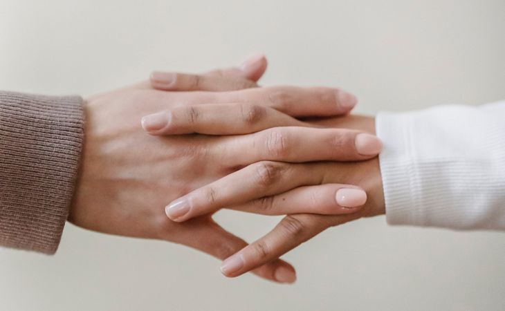 Zwei Hände, die sich sanft berühren und eine emotionale Verbindung sowie verschiedene Formen von Liebe symbolisieren.